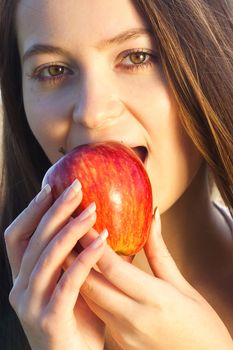 portrait of a beautiful young woman with apple  outdoor