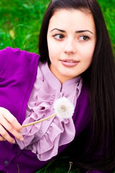 portrait of a beautiful young woman with dandelion