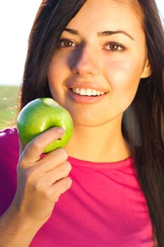 portrait of a beautiful young woman with apple  outdoor