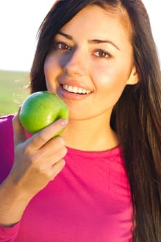 portrait of a beautiful young woman with apple  outdoor