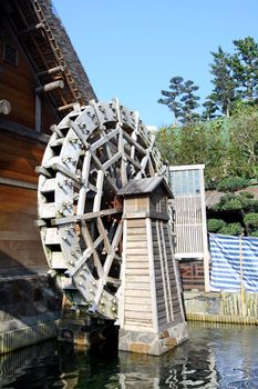 Water wheel next to a house