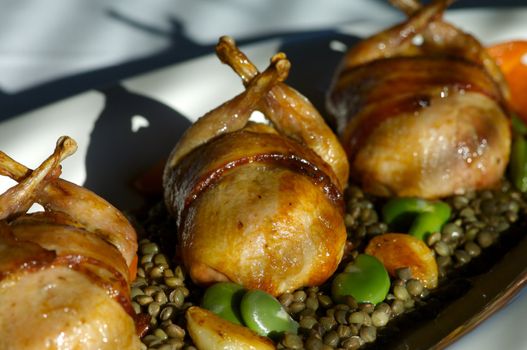 Image of bacon wrapped quail with vegetables