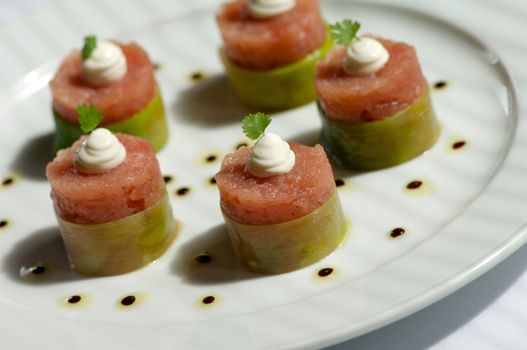 Image of raw tuna wrapped in bamboo and topped with garnish