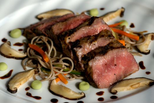 Image of seared sliced beef with vegetable garnish