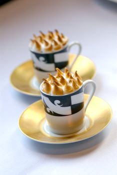 Image of mugs of cappaccino on saucers