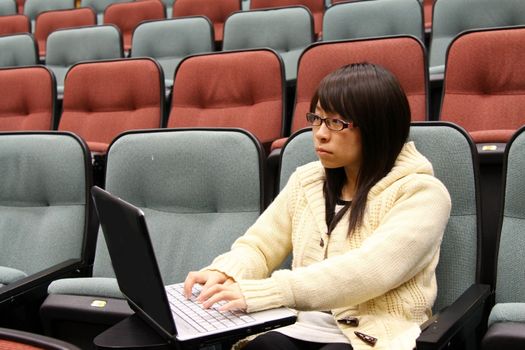 Asian university student using laptop and studying