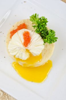 poached eggs in a nest of mashed potatoes with greens and caviar