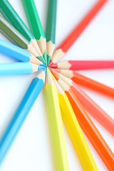 Color pencils in arrange in color wheel colors on white background