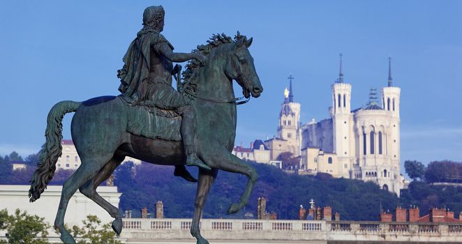 panoramic view of famous statue and Fourviere basilic on a background