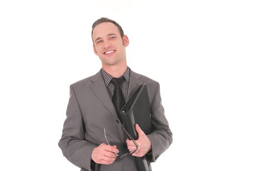 Smiling businessman with glasses in his hand a a black leather file under his arm standing looking at the camera isolated on white