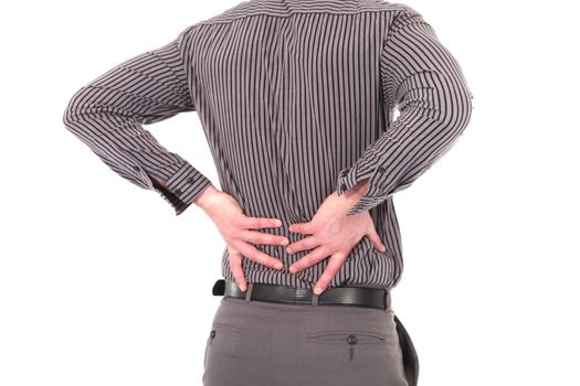 Man with lower back pain or backache caused by injury, stress or bad posture holding his back with both his hands, cropped torso portrait on white