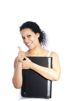 Happy attractive young African American woman with a lovely smile holding a leather folder giving a thumbs up of success and approval isolated on white