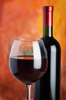 Wine, glass and the bottle on a colored background