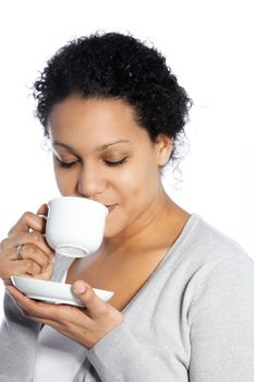 Studio shot of dark skinned lady enjoys her coffee isolated on white