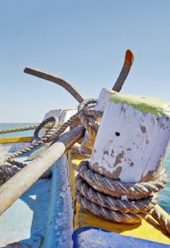 Dwarka Roadtrip. Vertical generic capture of anchor and tie ropes on a passenger ferry from Bet Dwarka to mainland India on the horizon in Gujarat