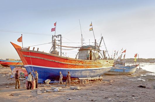 Landscape at the estuary of boatyard where a repair crew are in discussion on the strategy of a repair job