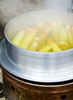 Street food in Taiwan - corn being made in a pot suspended above a fire using a metal frame