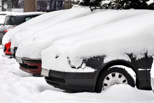 cars row on parking covered by snow