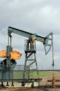 oilfield with worker and pump jack