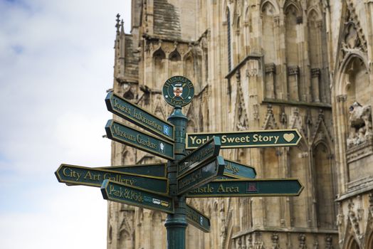Directions post in York, UK, with city crest and York Minster in detail the background