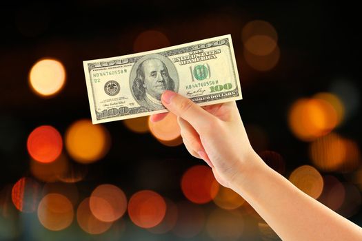 abstract of bokeh background with female hand holding money dollars