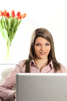 blond woman on sofa with laptop at home