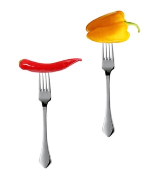 Red hot chili pepper with yellow pepper pricked on the steel fork