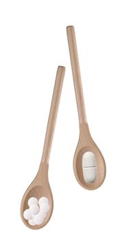 Tablets in a wooden spoon on a white background