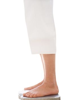 Bare female feet standing on bathroom scale