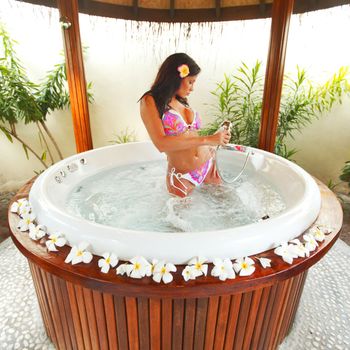 Pretty woman relaxing in jacuzzi of tropical hotel