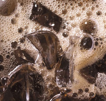 cola with ice cubes close up