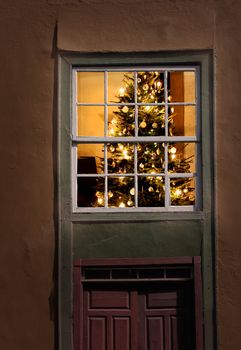 Christmas tree seen from outside of an old house window