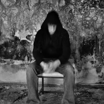 Man dissolving into textured black mold and peeling paint wall.