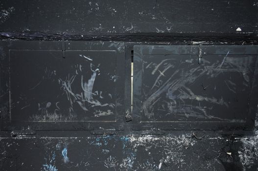 Black wall and charred window glass. Burned house interior.