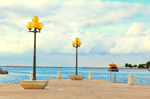 wooden berth with street-lamp on sea background. Pula Croatia