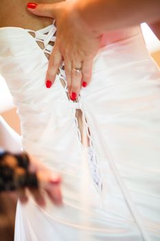 Bride getting dressed on her wedding day