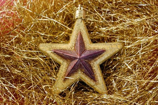 Christmas star bauble on golden background. Seasonal decoration.