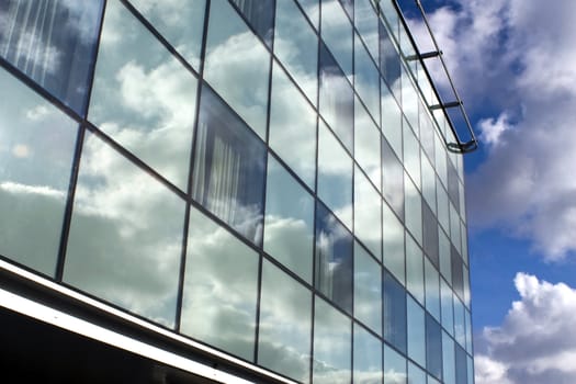 Skyscraper and reflections of blue sky and clouds.