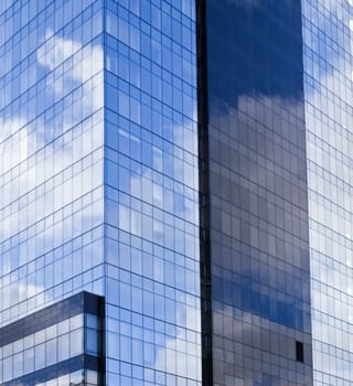 Skyscraper and reflections of blue sky and clouds.