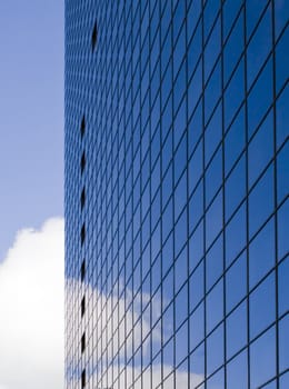 Skyscraper and reflections of blue sky and clouds.