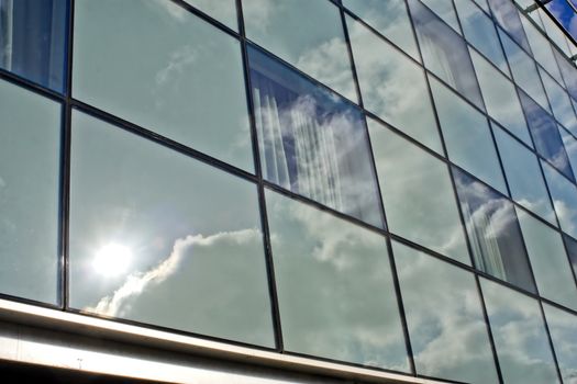 Skyscraper and reflections of blue sky and clouds.