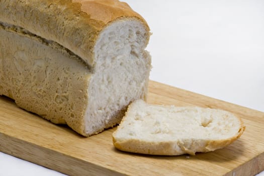 A fresh cut loaf on a wooden board