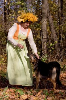 Woman and dog in autumn forest
