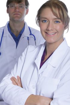 Two medical doctors, female in forefront. Both in white medical coats