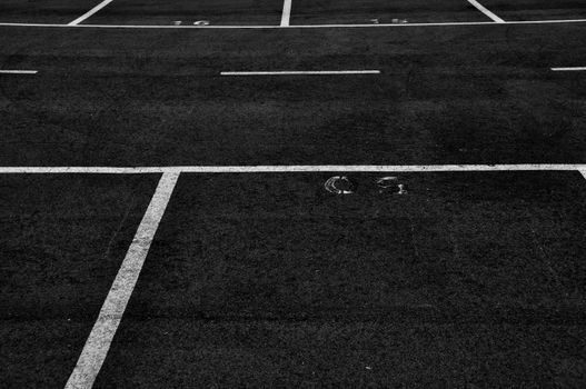Dividing lines in empty parking lot abstract background. Black and white.