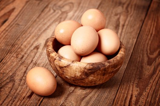 fresh brown eggs on wooden background