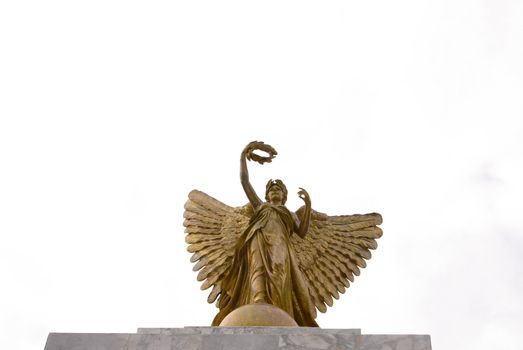 Golden angle statue with white sky