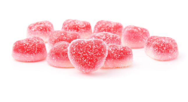red fruit candies in heart formation, isolated on white