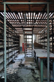 Empty shelves in abandoned vinyl records pressing factory storage room.