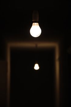 Bare light bulbs in dark underground hallway.